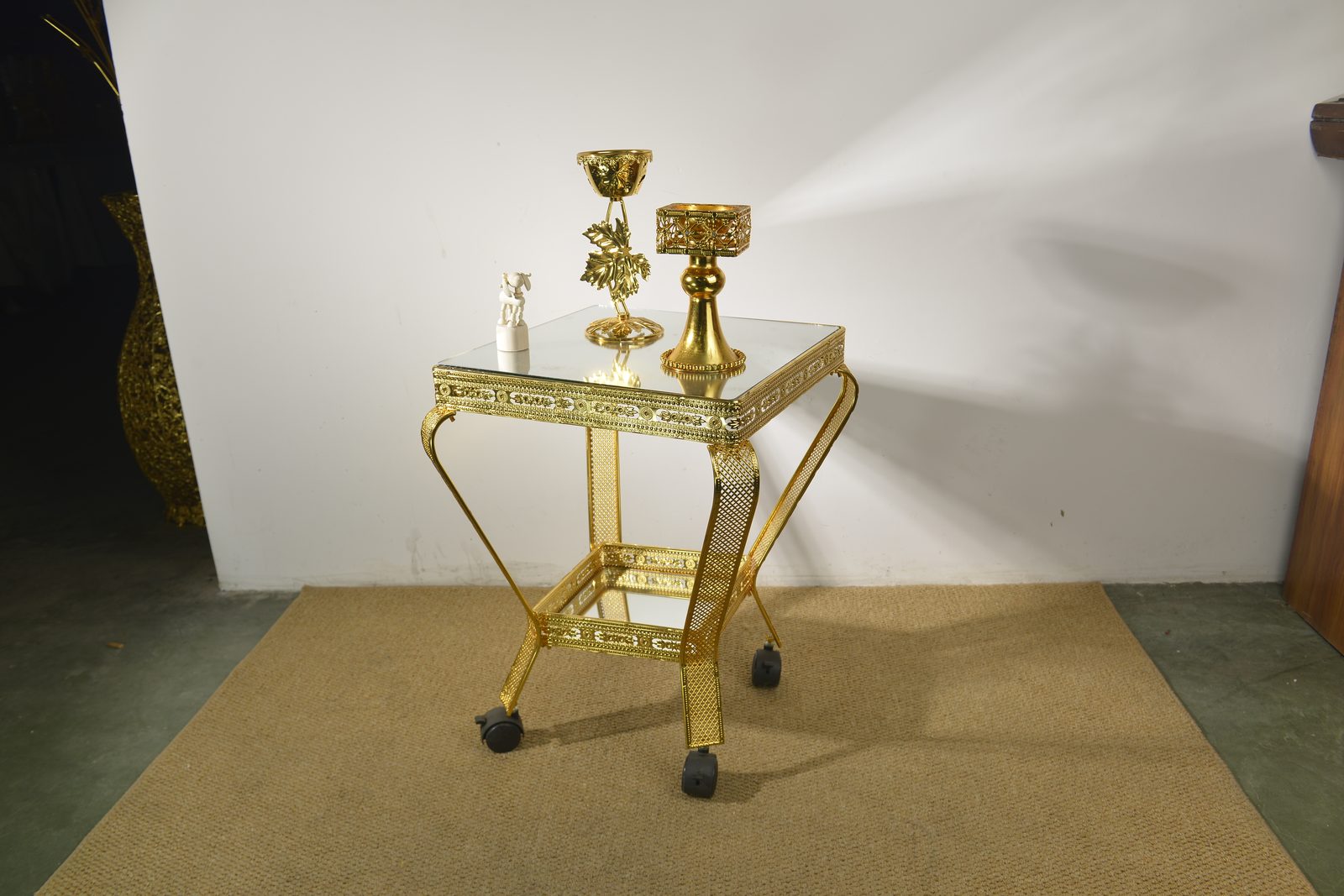 Square gold serving table with mirrored top and casters